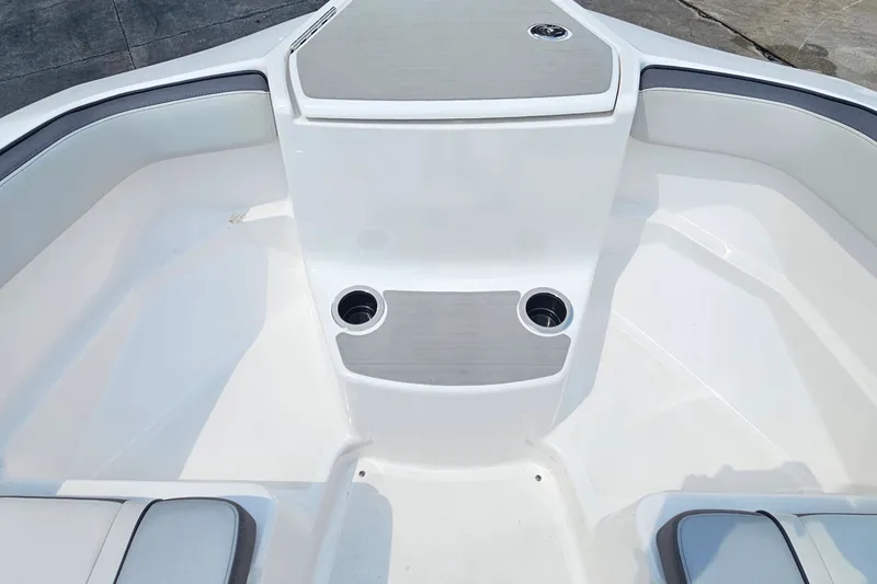 Slide: The Image of 2023 Yamaha Boats AR250 bow seating area with cup holders and sleek design. - 11
