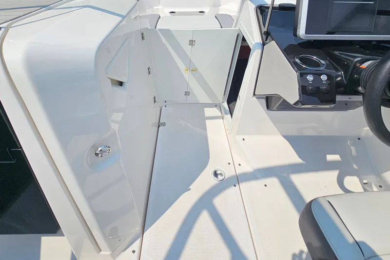 Slide: The Image of 2023 Yamaha Boats AR250 interior cockpit with steering wheel and storage compartment. - 16