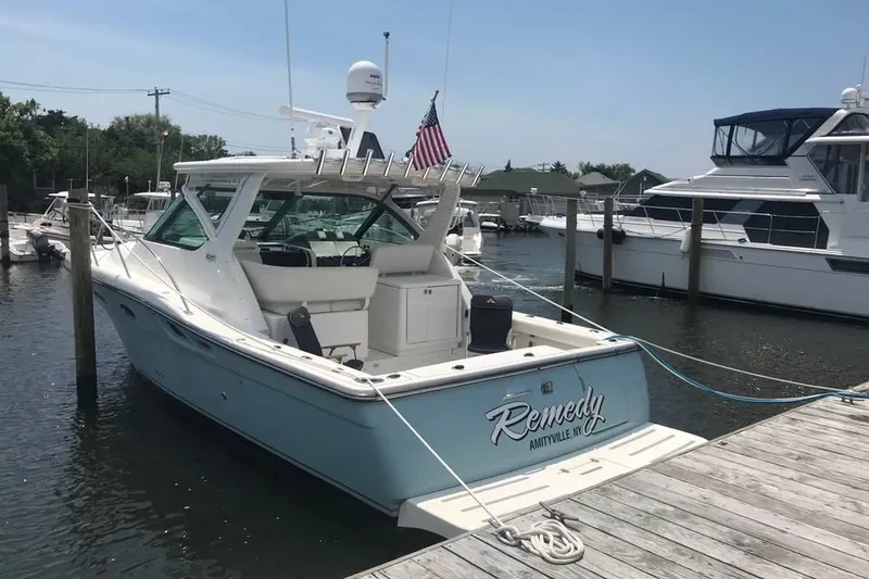Slide: The Image of 2006 Tiara 32 OPEN boat docked at marina, featuring "Remedy" name and American flag. - 1