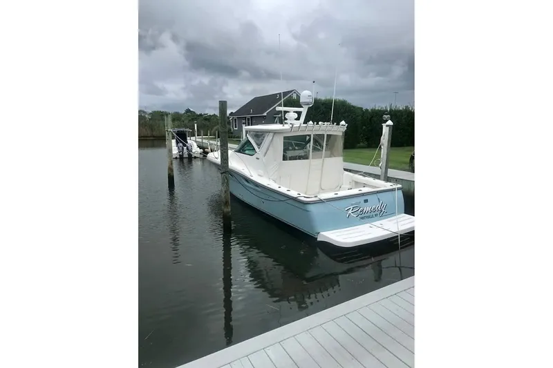 Slide: The Image of 2006 Tiara 32 OPEN boat docked on a cloudy day. - 2