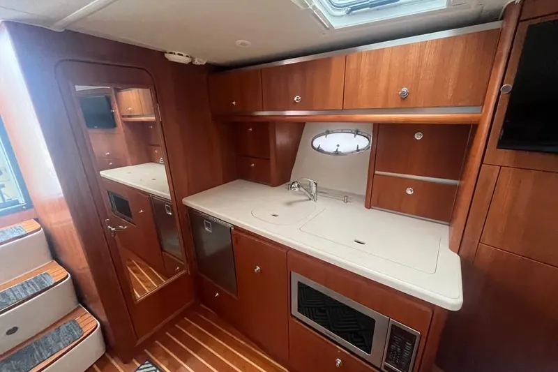 Slide: The Image of Luxurious 2006 Tiara 32 OPEN yacht interior with wooden cabinetry and modern kitchen amenities. - 16