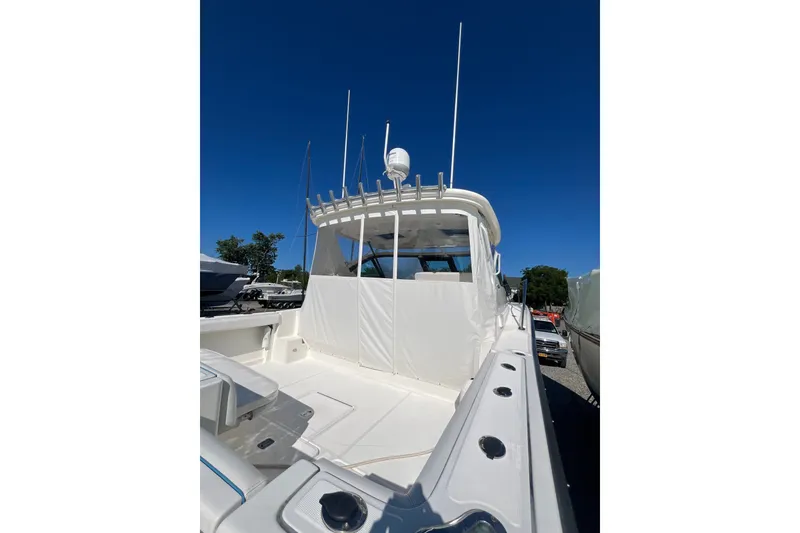Slide: The Image of 2006 Tiara 32 OPEN boat with white exterior, docked under clear blue sky. - 5