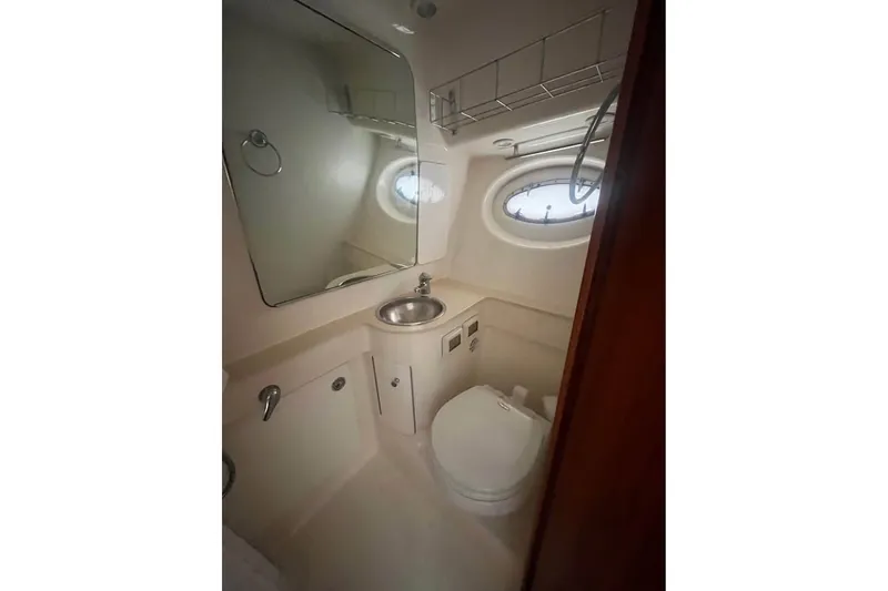 Slide: The Image of Compact bathroom in 2006 Tiara 32 OPEN yacht with sink, toilet, and porthole window. - 13