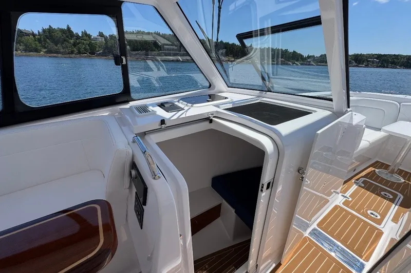 Slide: The Image of 2024 Southport 33 DC boat interior with cabin and scenic water view. - 19