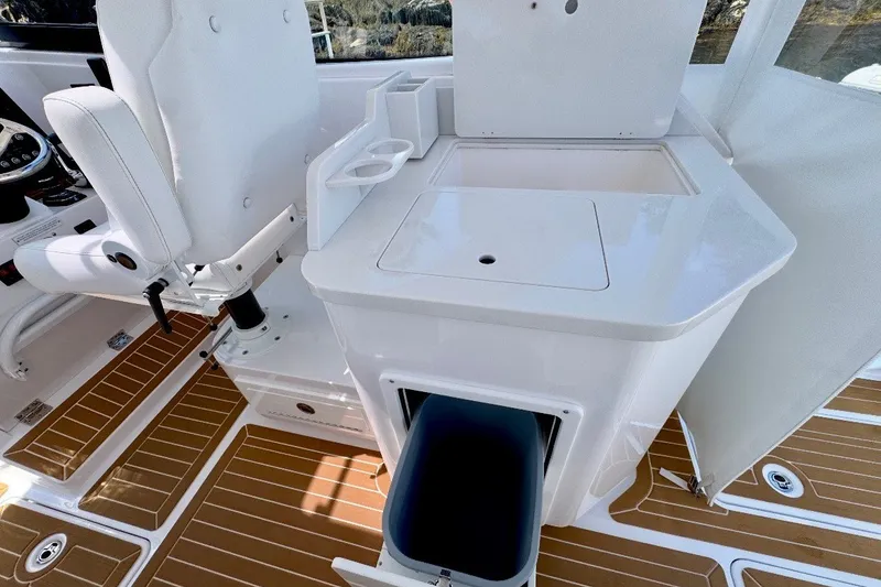 Slide: The Image of 2024 Southport 33 DC boat interior with white seating and storage compartment. - 15