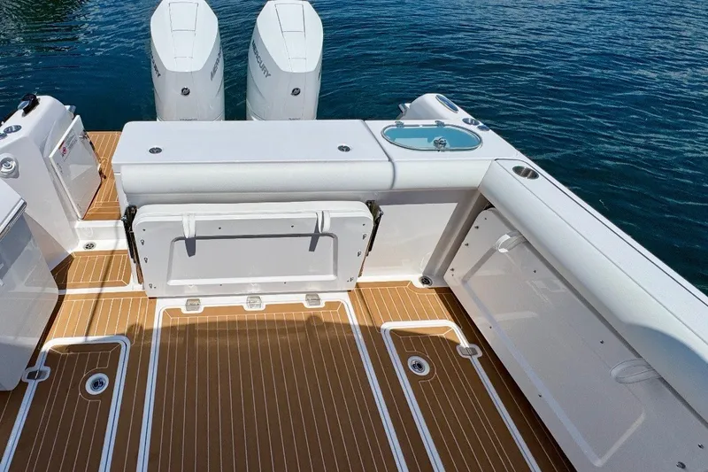 Slide: The Image of 2024 Southport 33 DC boat deck with twin Mercury engines, featuring sleek design and wood-like flooring. - 9