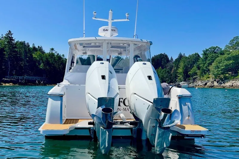 Slide: The Image of 2024 Southport 33 DC boat with dual engines on a serene lake. - 7