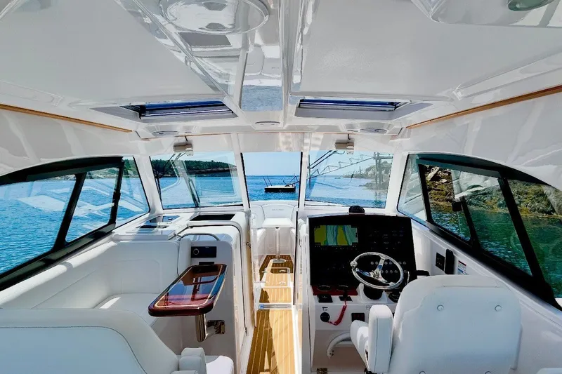 Slide: The Image of Interior view of 2024 Southport 33 DC boat, featuring modern helm and panoramic windows. - 13
