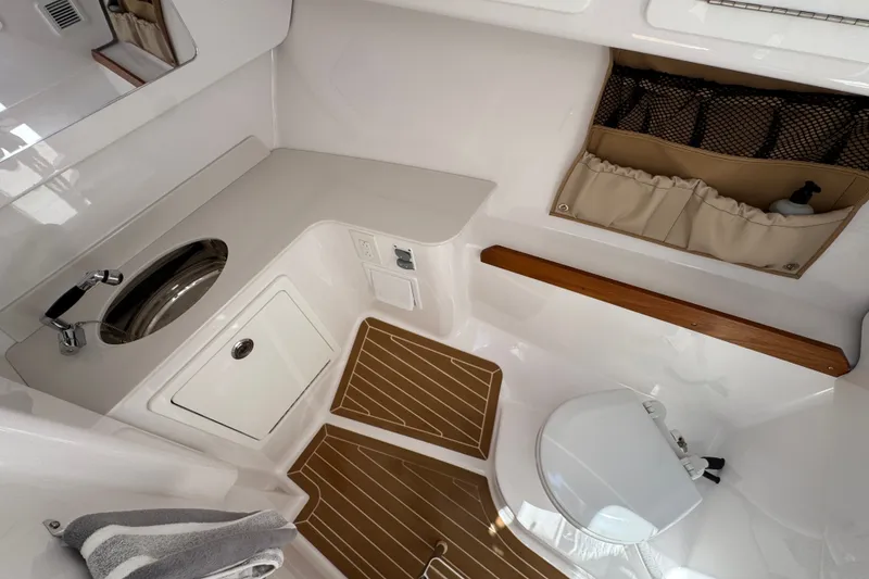 Slide: The Image of 2024 Southport 33 DC boat interior with sink, storage, and wooden accents. - 23