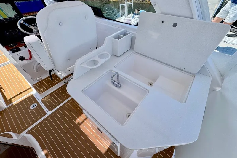 Slide: The Image of 2024 Southport 33 DC boat interior with helm seat and sink area. - 14