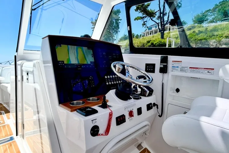Slide: The Image of 2024 Southport 33 DC boat cockpit with advanced navigation system and sleek steering wheel. - 17