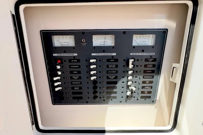 Slide: The Image of Electrical control panel on a 2024 Southport 33 DC boat, featuring various switches and gauges. - 25