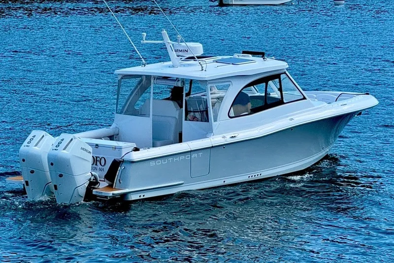 Slide: The Image of 2024 Southport 33 DC boat cruising on blue water with twin outboard engines. - 6