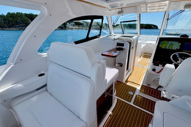 Slide: The Image of Luxurious interior of 2024 Southport 33 DC boat with white seating and wooden flooring. - 12
