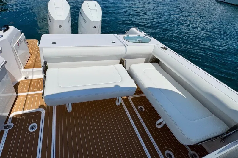 Slide: The Image of 2024 Southport 33 DC boat with white seating and twin Mercury engines on teak deck. - 10
