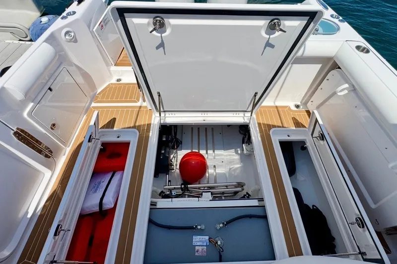 Slide: The Image of 2024 Southport 33 DC boat storage compartments with open hatches, showcasing interior organization. - 11