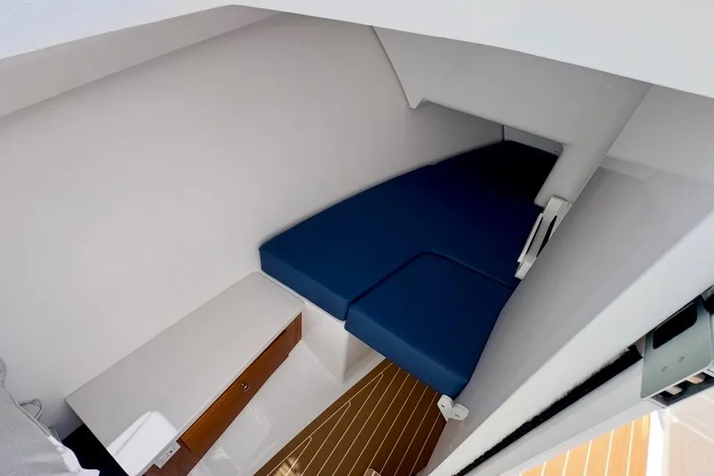 Slide: The Image of 2024 Southport 33 DC cabin interior with blue cushions and wooden flooring. - 21