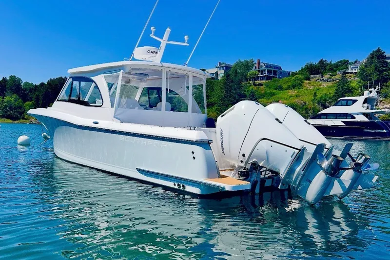Slide: The Image of 2024 Southport 33 DC boat with dual engines on a sunny day in a scenic harbor. - 1