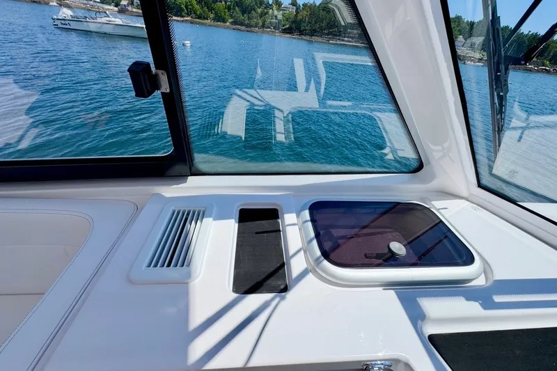 Slide: The Image of 2024 Southport 33 DC boat interior with window view of serene blue water. - 20