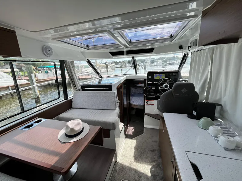Slide: The Image of Interior of 2022 Jeanneau NC 1095 boat with modern helm and seating area. - 2