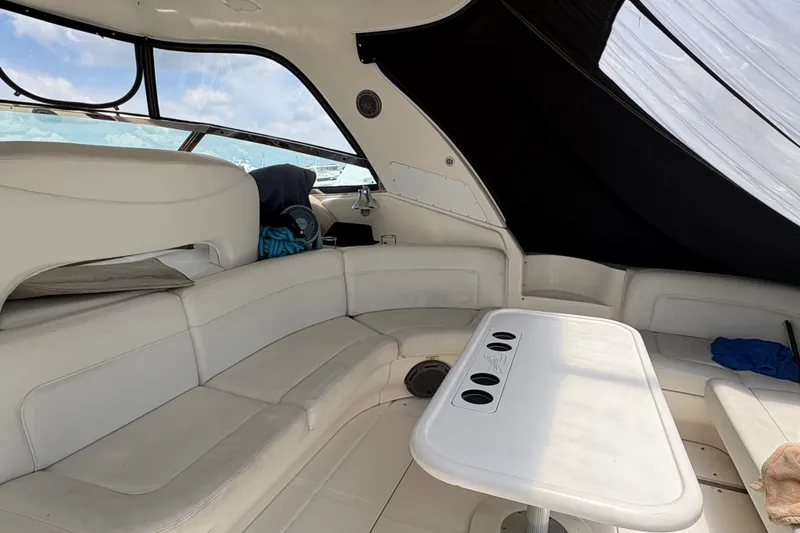 Slide: The Image of Interior of a 2001 Sea Ray Sundancer 460 yacht with white seating and table. - 24