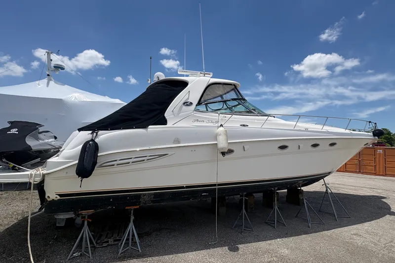 The Image of 2001 Sea Ray Sundancer 460 yacht on stands under a clear blue sky. - 1