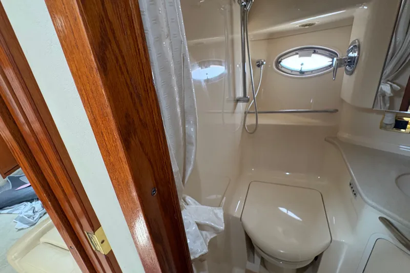 Slide: The Image of Bathroom interior of 2001 Sea Ray Sundancer 460 yacht, featuring shower and wooden door. - 15