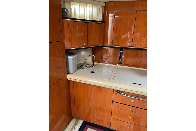 Slide: The Image of 2001 Sea Ray Sundancer 460 yacht kitchen with wooden cabinets and sink. - 38