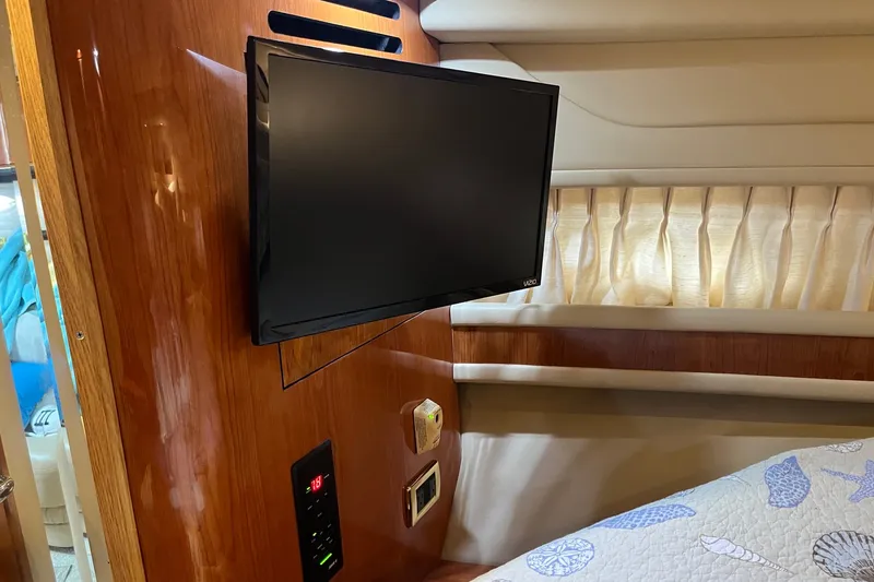 Slide: The Image of Flat-screen TV in 2001 Sea Ray Sundancer 460 cabin with wood paneling and cozy bedding. - 31