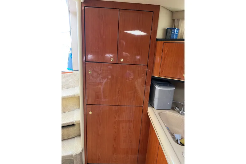 Slide: The Image of Interior of 2001 Sea Ray Sundancer 460 with wooden cabinetry and compact kitchen area. - 35