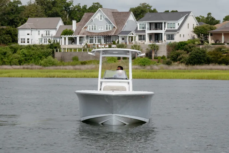 Slide: The Image of 2023 Sportsman Heritage 231 Center Console boat on water, with houses in the background. - 1