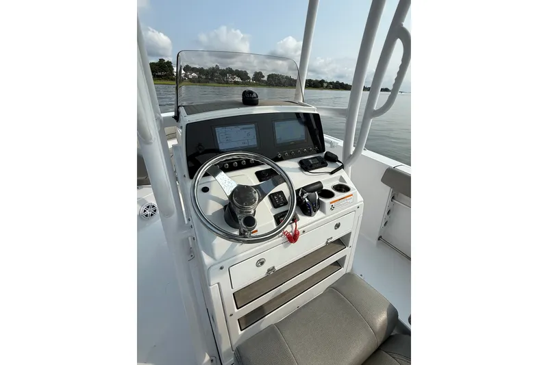 Slide: The Image of 2023 Sportsman Heritage 231 Center Console boat dashboard with steering wheel and navigation screens. - 9