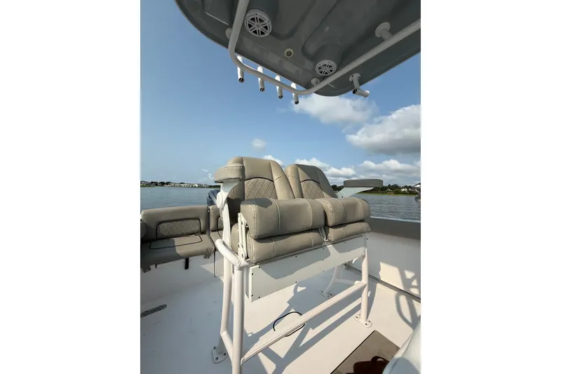 Slide: The Image of 2023 Sportsman Heritage 231 Center Console boat interior with cushioned seating and rod holders. - 11