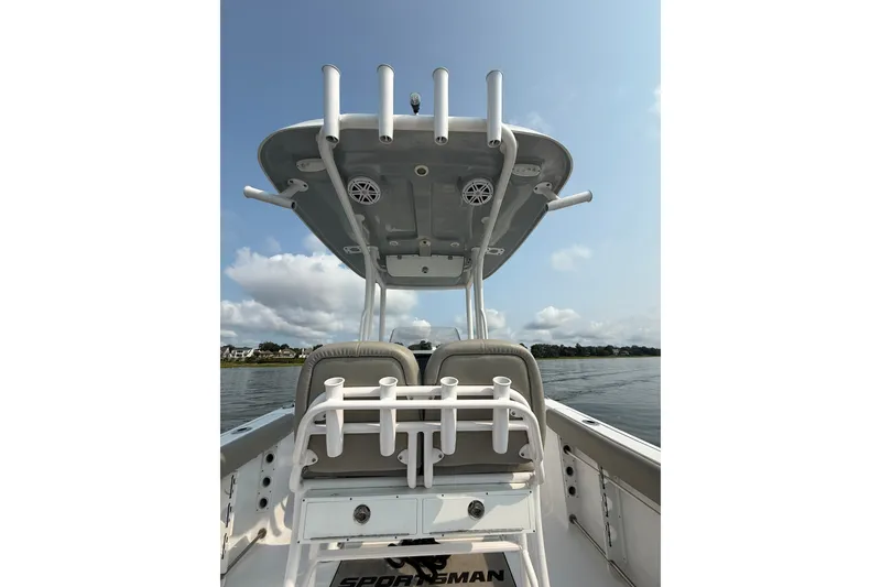 Slide: The Image of 2023 Sportsman Heritage 231 Center Console boat on calm water, showcasing seating and T-top. - 12