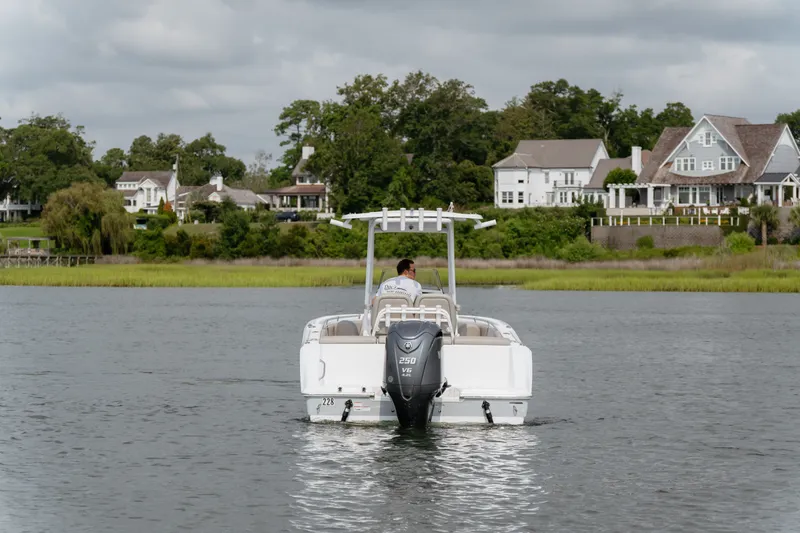 Slide: The Image of 2023 Sportsman Heritage 231 Center Console boat cruising near waterfront homes. - 15