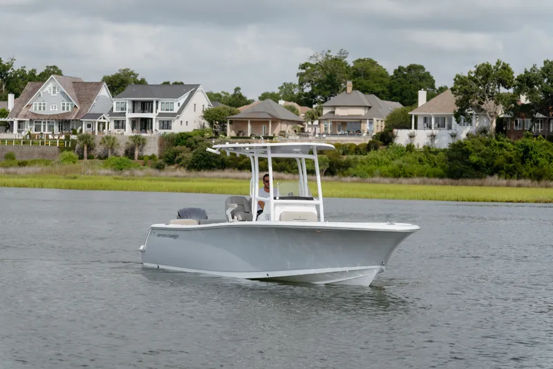 Slide: The Image of 2023 Sportsman Heritage 231 Center Console boat cruising near waterfront homes. - 19