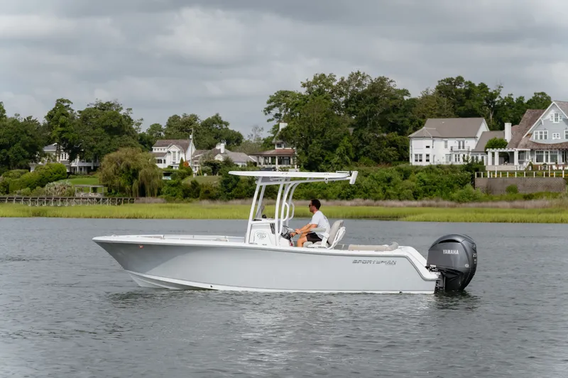 Slide: The Image of 2023 Sportsman Heritage 231 Center Console boat cruising on a calm river near waterfront homes. - 4