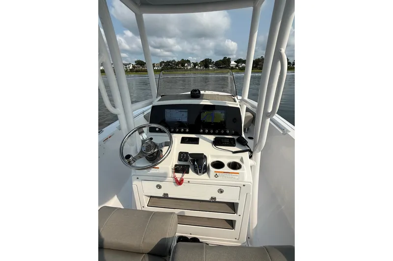 Slide: The Image of 2023 Sportsman Heritage 231 Center Console boat interior with steering wheel and navigation system. - 22