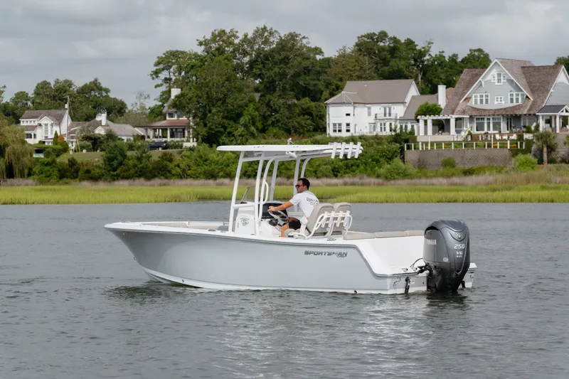 Slide: The Image of 2023 Sportsman Heritage 231 Center Console boat cruising near waterfront homes. - 17