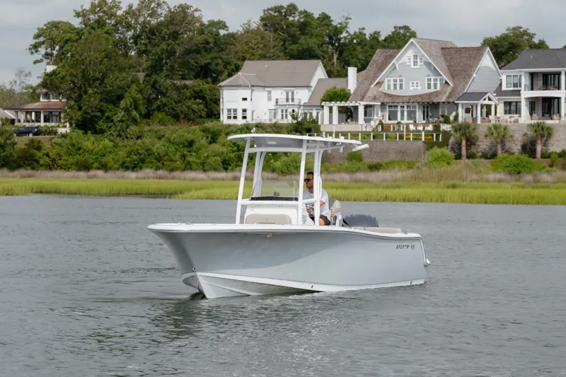Slide: The Image of 2023 Sportsman Heritage 231 Center Console boat cruising near waterfront homes. - 18