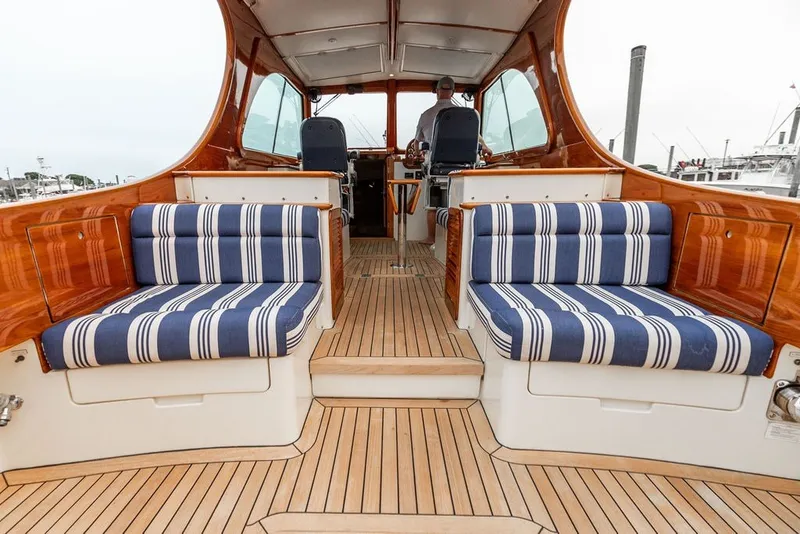 Slide: The Image of Interior of 2012 Hinckley Picnic Boat MKIII with striped seating and wooden finishes. - 31
