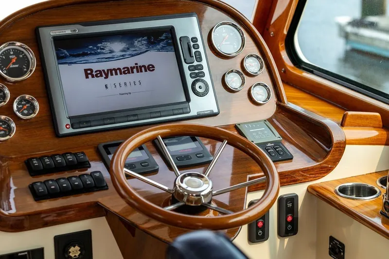 Slide: The Image of Hinckley Picnic Boat MKIII 2012 dashboard with Raymarine navigation system and wooden steering wheel. - 9