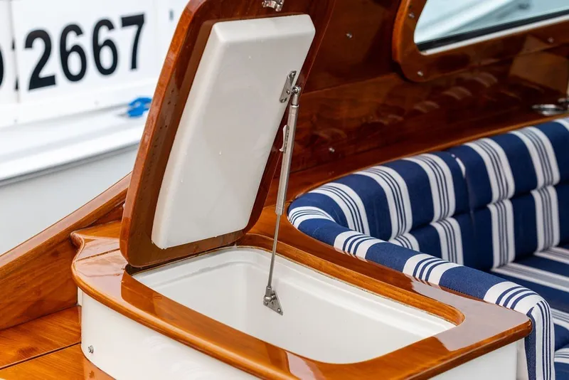 Slide: The Image of Hinckley Picnic Boat MKIII 2012 interior with open storage and striped seating. - 26