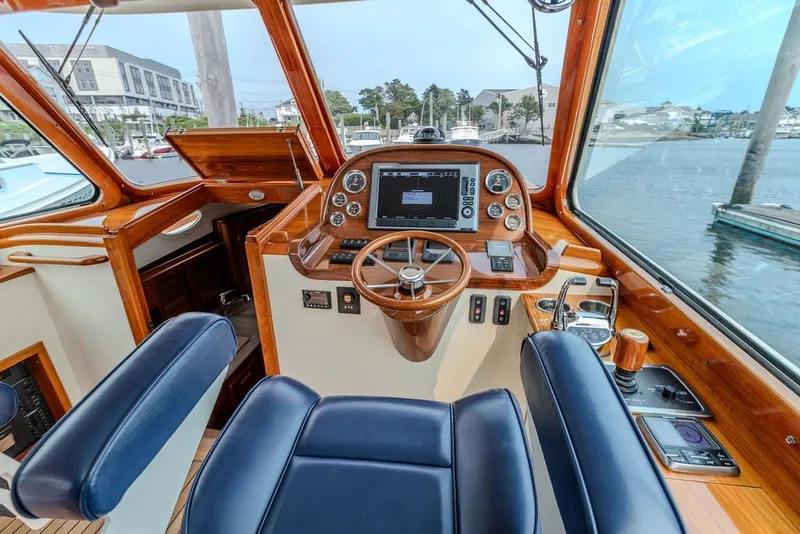 Slide: The Image of Interior of 2012 Hinckley Picnic Boat MKIII with elegant wooden helm and modern controls. - 1