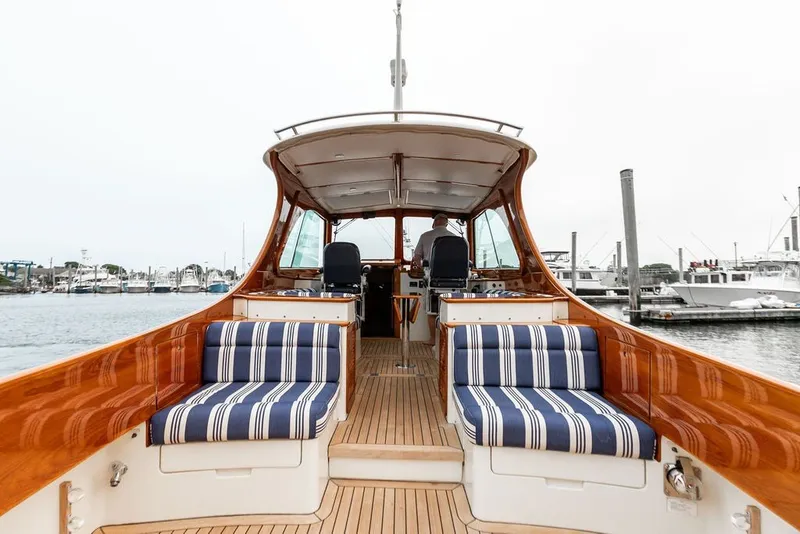 Slide: The Image of 2012 Hinckley Picnic Boat MKIII with striped seating, docked at a marina. - 2