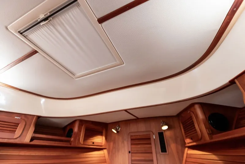 Slide: The Image of Interior of 2012 Hinckley Picnic Boat MKIII, featuring elegant wood paneling and ceiling details. - 20