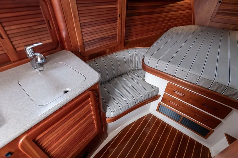 Slide: The Image of Interior of 2012 Hinckley Picnic Boat MKIII with wood finish and striped upholstery. - 22