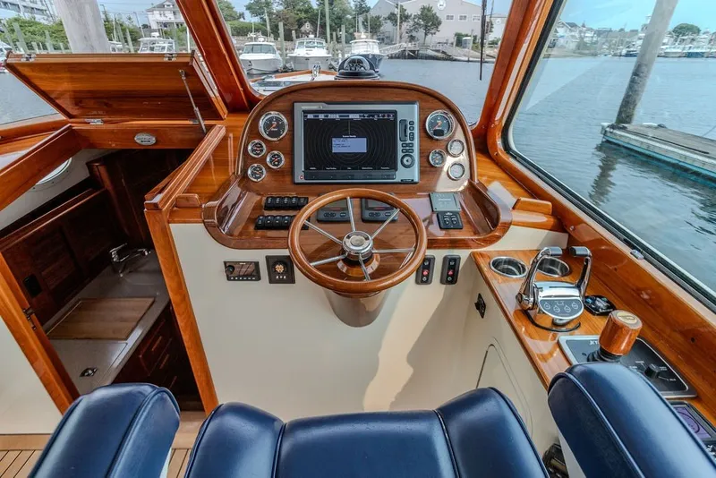 Slide: The Image of Helm of 2012 Hinckley Picnic Boat MKIII with wooden dashboard and navigation controls. - 8