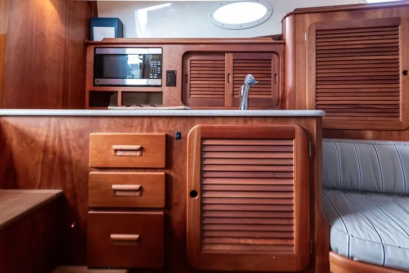 Slide: The Image of Interior of 2012 Hinckley Picnic Boat MKIII with wooden cabinetry and modern amenities. - 15