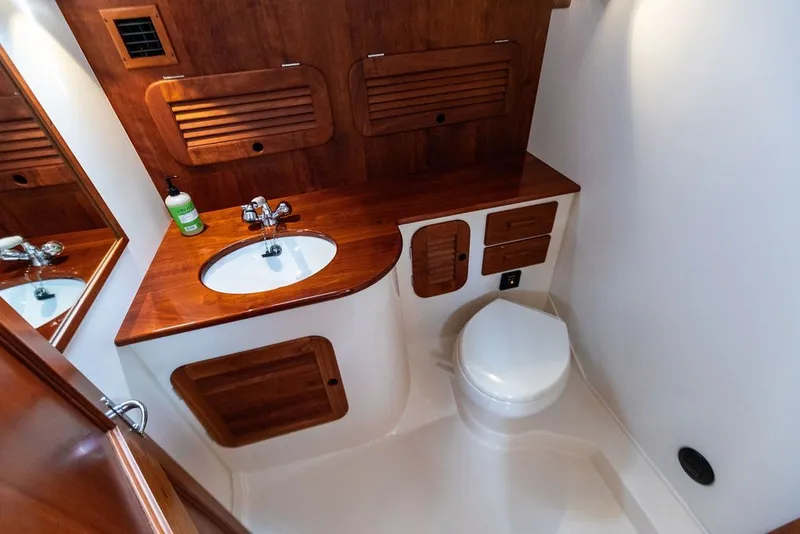 Slide: The Image of Luxurious 2012 Hinckley Picnic Boat MKIII bathroom with wooden cabinetry and modern fixtures. - 23